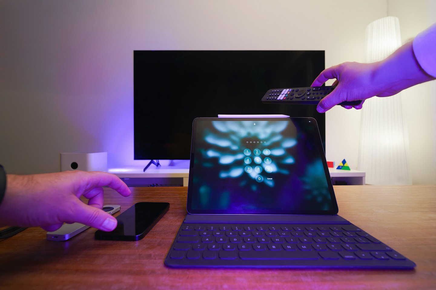 Dłonie sterujące technologią inteligentnego domu na biurku.