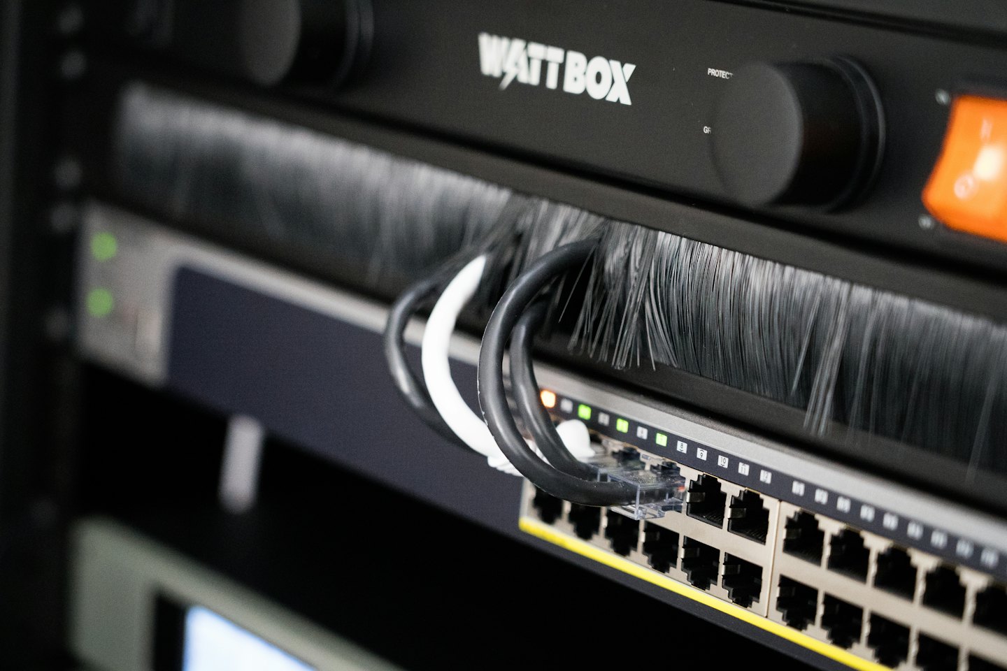 Serwerownia z kablami sieciowymi i jednostką zasilającą Wattbox.